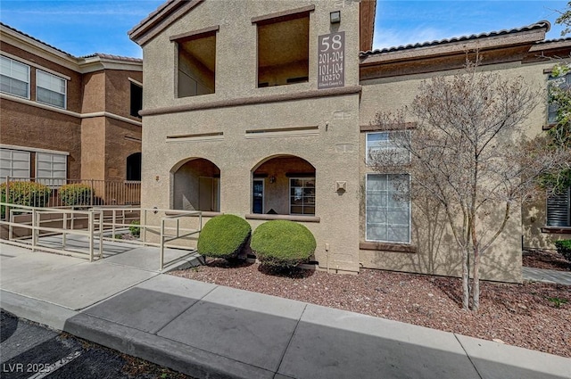 view of front of home featuring stucco siding and a tile roof