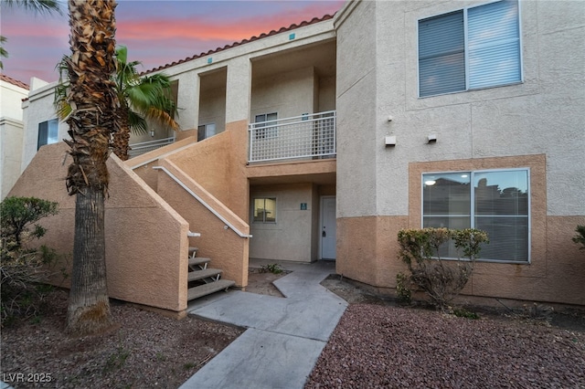 property at dusk featuring stairway