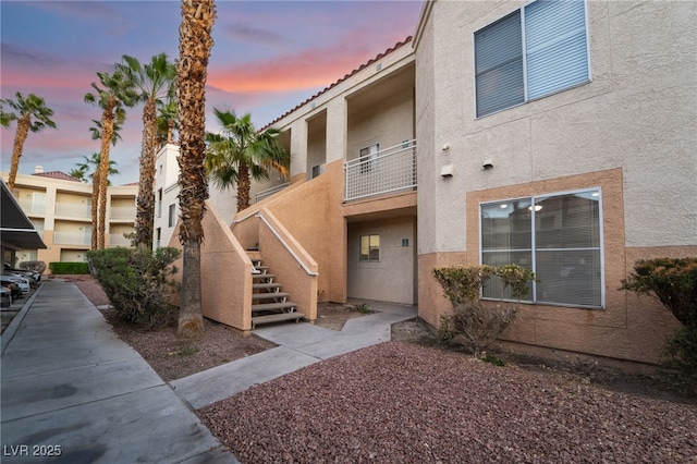 property at dusk featuring stairs