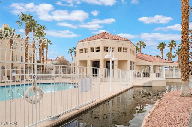 community pool with a patio and fence