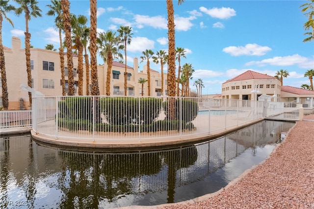 view of property's community featuring a water view and fence