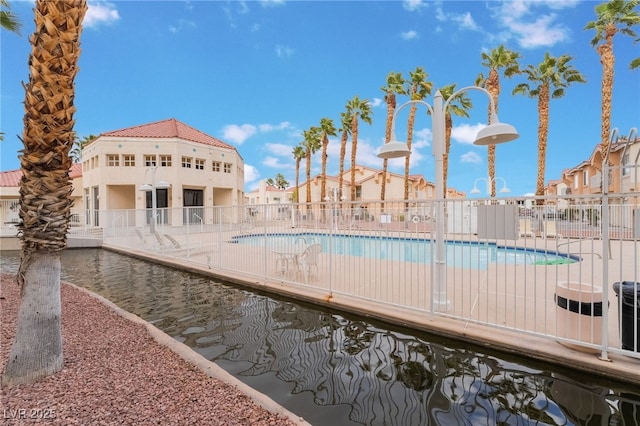 pool with fence and a residential view