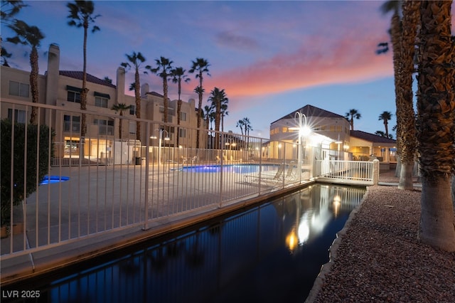 pool featuring a water view and fence