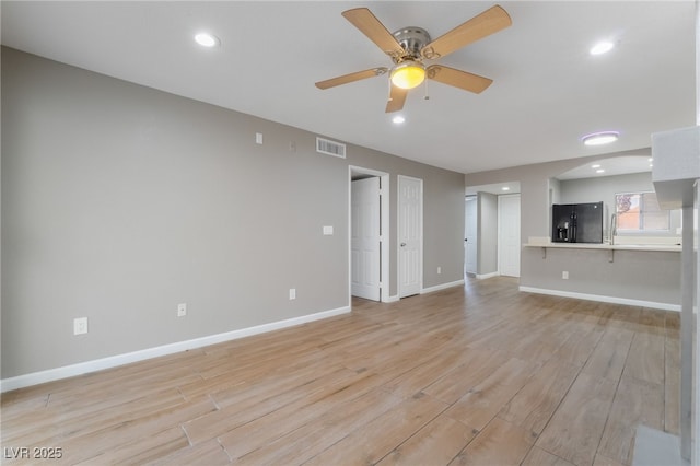 unfurnished living room with a ceiling fan, recessed lighting, baseboards, and light wood-type flooring