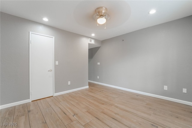 unfurnished room featuring baseboards, light wood-style floors, and ceiling fan