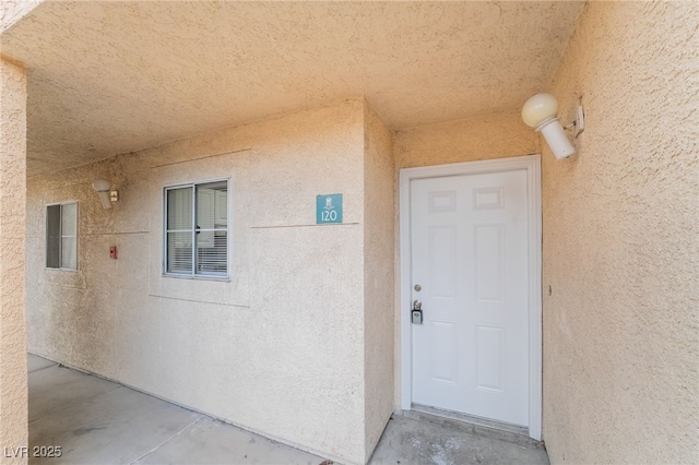 view of exterior entry featuring stucco siding