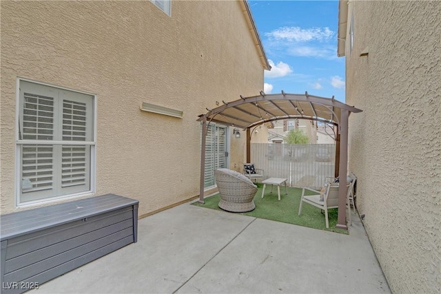 view of patio with a pergola and fence