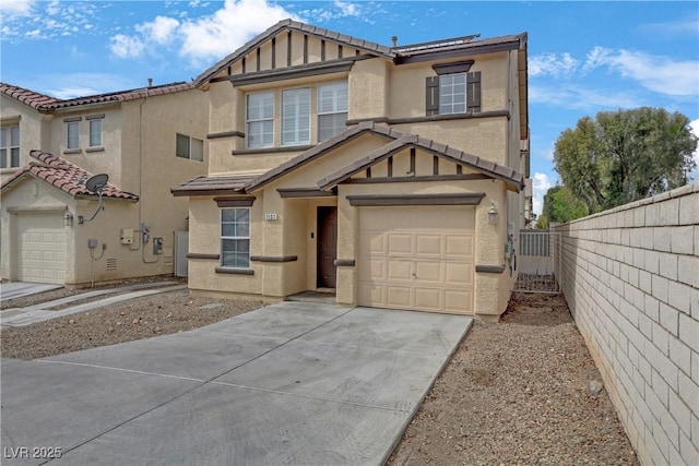 view of front facade featuring fence, driveway, stucco siding, a garage, and a tiled roof