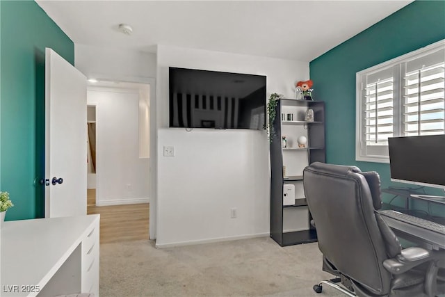 office space featuring baseboards and light carpet