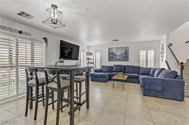 living room with a wealth of natural light, visible vents, and stairway