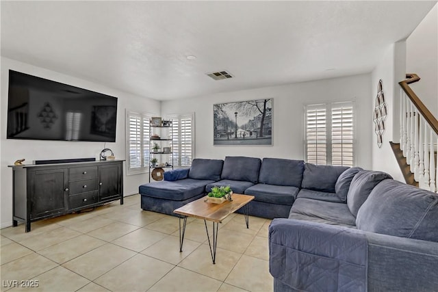 living room with stairs, light tile patterned floors, and visible vents