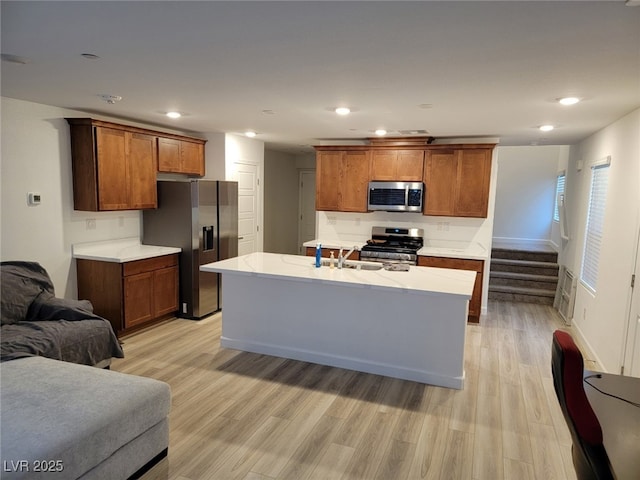 kitchen with brown cabinetry, light wood-type flooring, recessed lighting, appliances with stainless steel finishes, and open floor plan