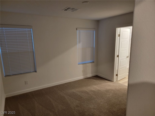 unfurnished room featuring visible vents, carpet flooring, and baseboards