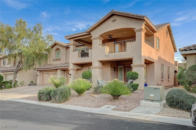 mediterranean / spanish house with concrete driveway, stucco siding, a balcony, a garage, and a ceiling fan