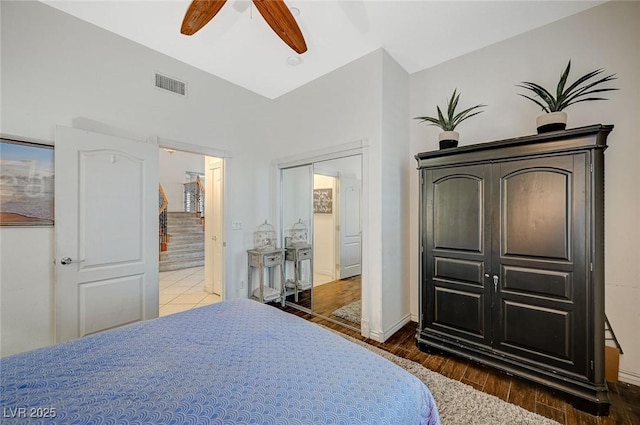 bedroom with wood finished floors, baseboards, visible vents, ceiling fan, and connected bathroom