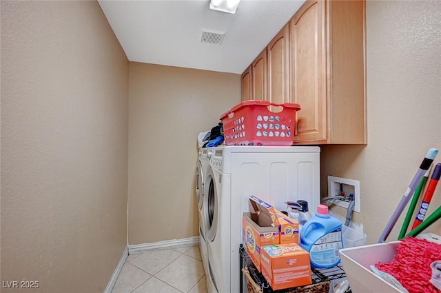 laundry area with visible vents, cabinet space, light tile patterned flooring, baseboards, and washing machine and clothes dryer