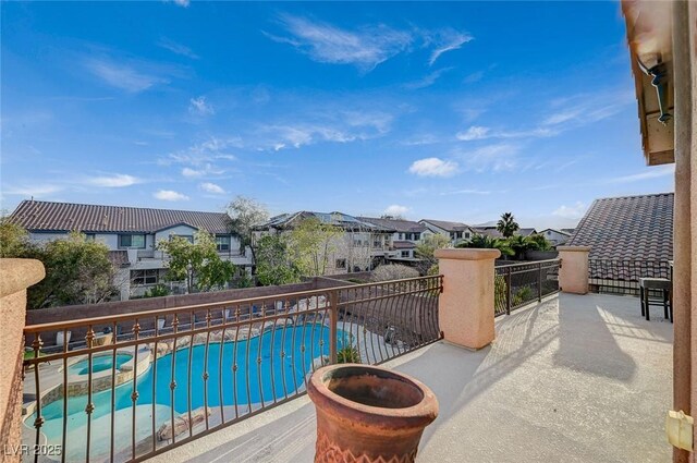 balcony with a residential view and a pool with connected hot tub