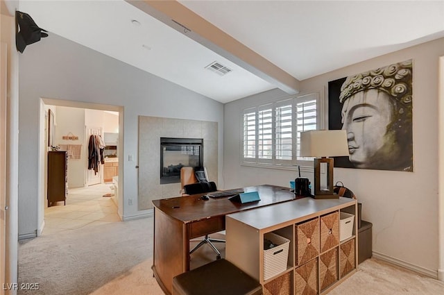 office with visible vents, carpet, vaulted ceiling with beams, and a tiled fireplace