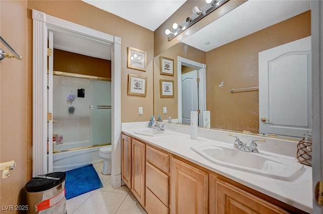 bathroom with a sink, enclosed tub / shower combo, double vanity, and tile patterned floors