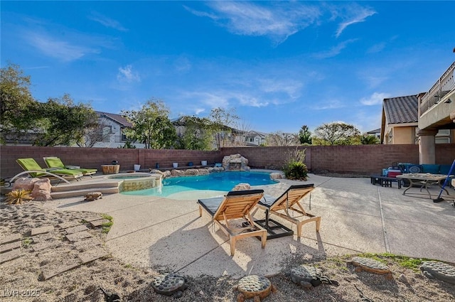 view of swimming pool featuring a pool with connected hot tub, a patio area, and a fenced backyard