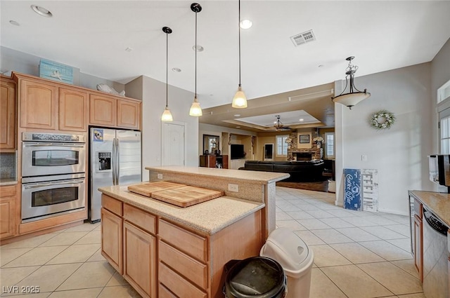 kitchen with light tile patterned floors, visible vents, a kitchen island, and stainless steel appliances