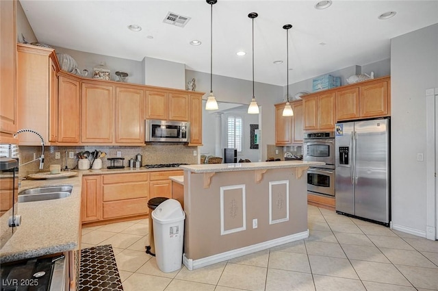 kitchen with visible vents, light tile patterned flooring, a sink, appliances with stainless steel finishes, and a center island