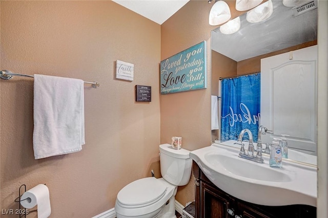 bathroom featuring vanity, toilet, baseboards, and visible vents