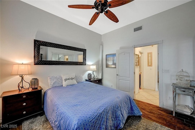 bedroom featuring ceiling fan, visible vents, lofted ceiling, and wood finished floors