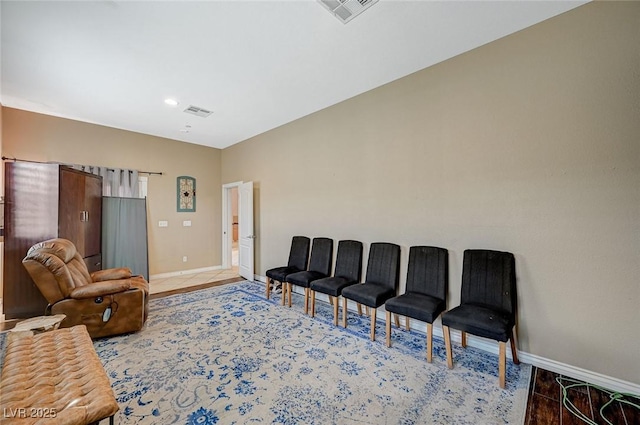 living area featuring baseboards, visible vents, and light wood finished floors