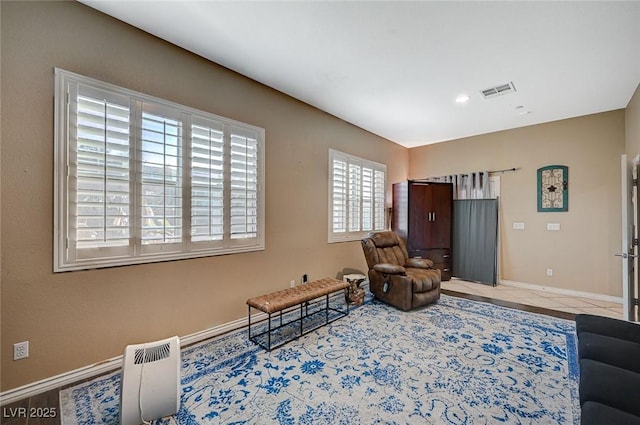 sitting room featuring tile patterned floors, visible vents, and baseboards