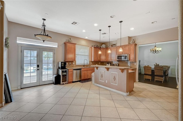 kitchen featuring visible vents, a kitchen breakfast bar, stainless steel appliances, french doors, and light countertops