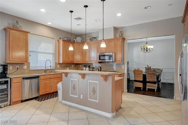 kitchen featuring visible vents, a sink, stainless steel appliances, wine cooler, and light tile patterned flooring