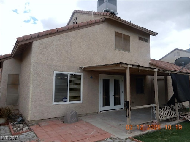 rear view of house featuring french doors, a patio area, central AC unit, and stucco siding