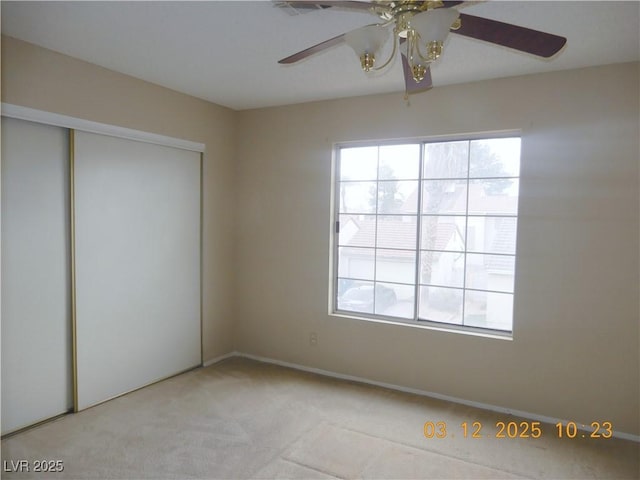 interior space featuring a closet, light carpet, and ceiling fan