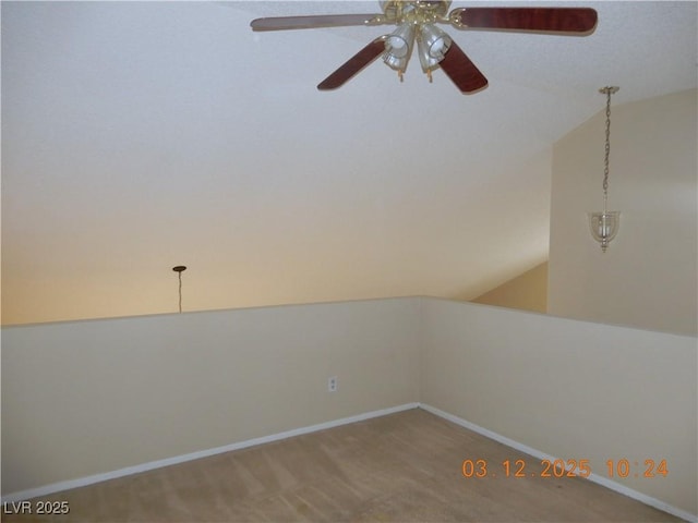 spare room featuring lofted ceiling, carpet flooring, and baseboards