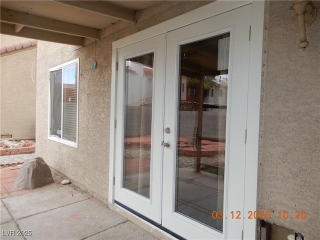 entrance to property with french doors and stucco siding