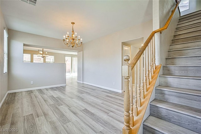 interior space featuring a chandelier, visible vents, baseboards, and wood finished floors