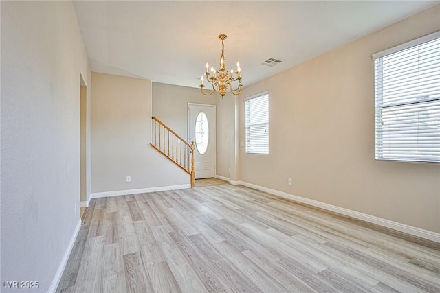 entryway with visible vents, stairway, light wood finished floors, baseboards, and a chandelier