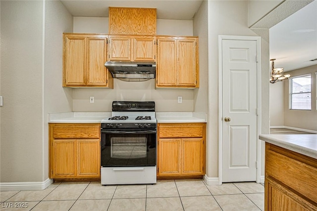 kitchen featuring ventilation hood, range with gas stovetop, light countertops, and light tile patterned floors