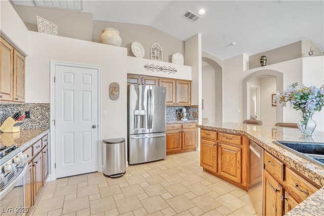 kitchen with light countertops, arched walkways, visible vents, and appliances with stainless steel finishes