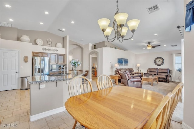 dining space with visible vents, vaulted ceiling, ceiling fan with notable chandelier, recessed lighting, and arched walkways