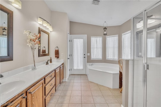 full bath featuring tile patterned flooring, a bath, visible vents, and a sink