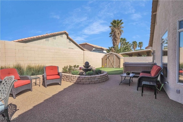 view of patio with a storage unit, an outbuilding, a fenced backyard, and a hot tub