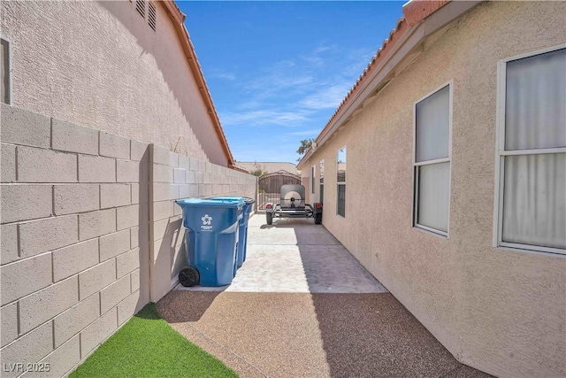 view of side of property featuring fence and stucco siding