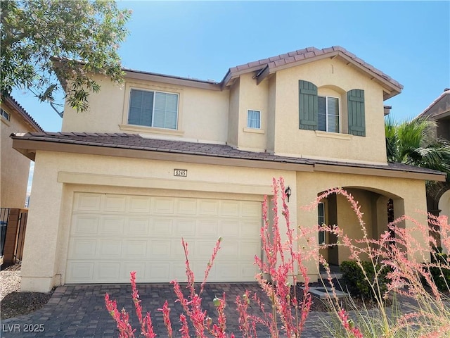 view of front facade featuring an attached garage, driveway, and stucco siding