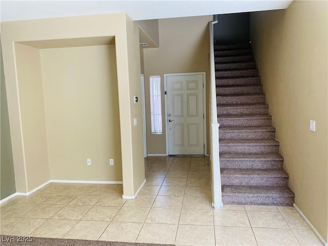 stairway with baseboards and tile patterned flooring