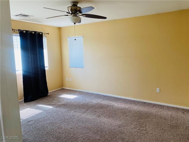 unfurnished room with visible vents, carpet floors, baseboards, and a ceiling fan