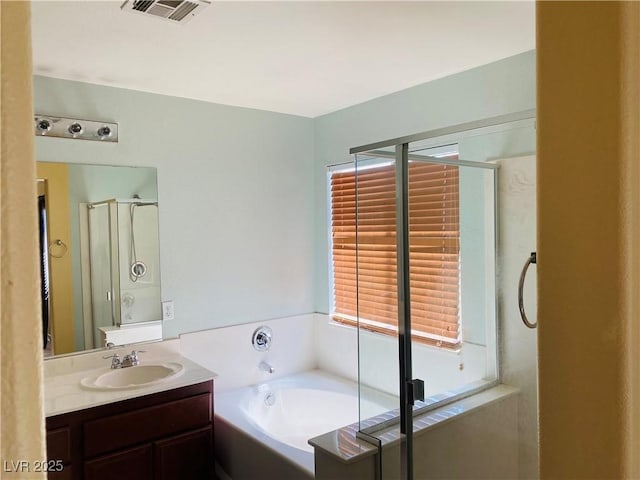 full bath with visible vents, a stall shower, vanity, and a garden tub