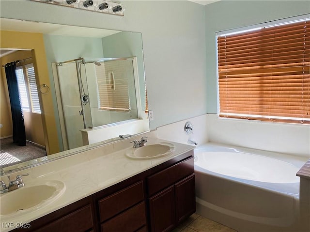 bathroom featuring a garden tub, double vanity, a stall shower, and a sink