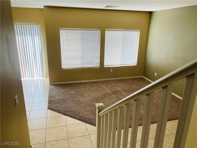 interior space with tile patterned floors, visible vents, carpet floors, and baseboards